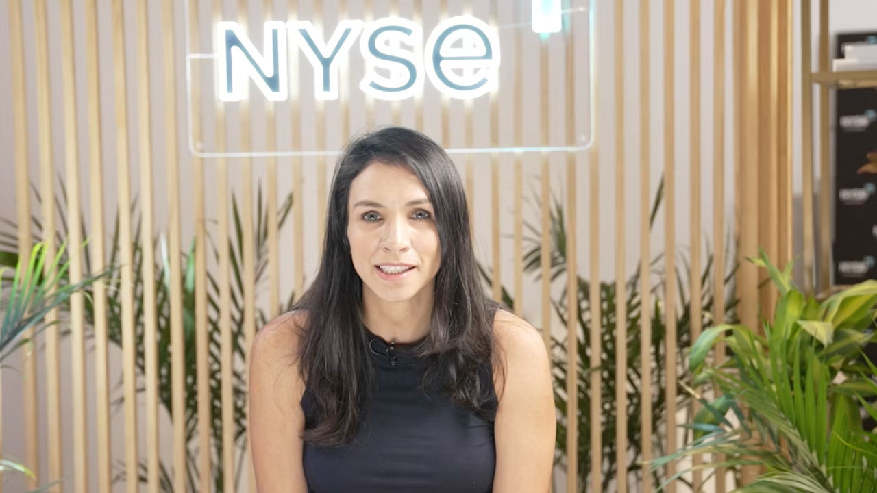 woman speaking with NYSE sign behind her